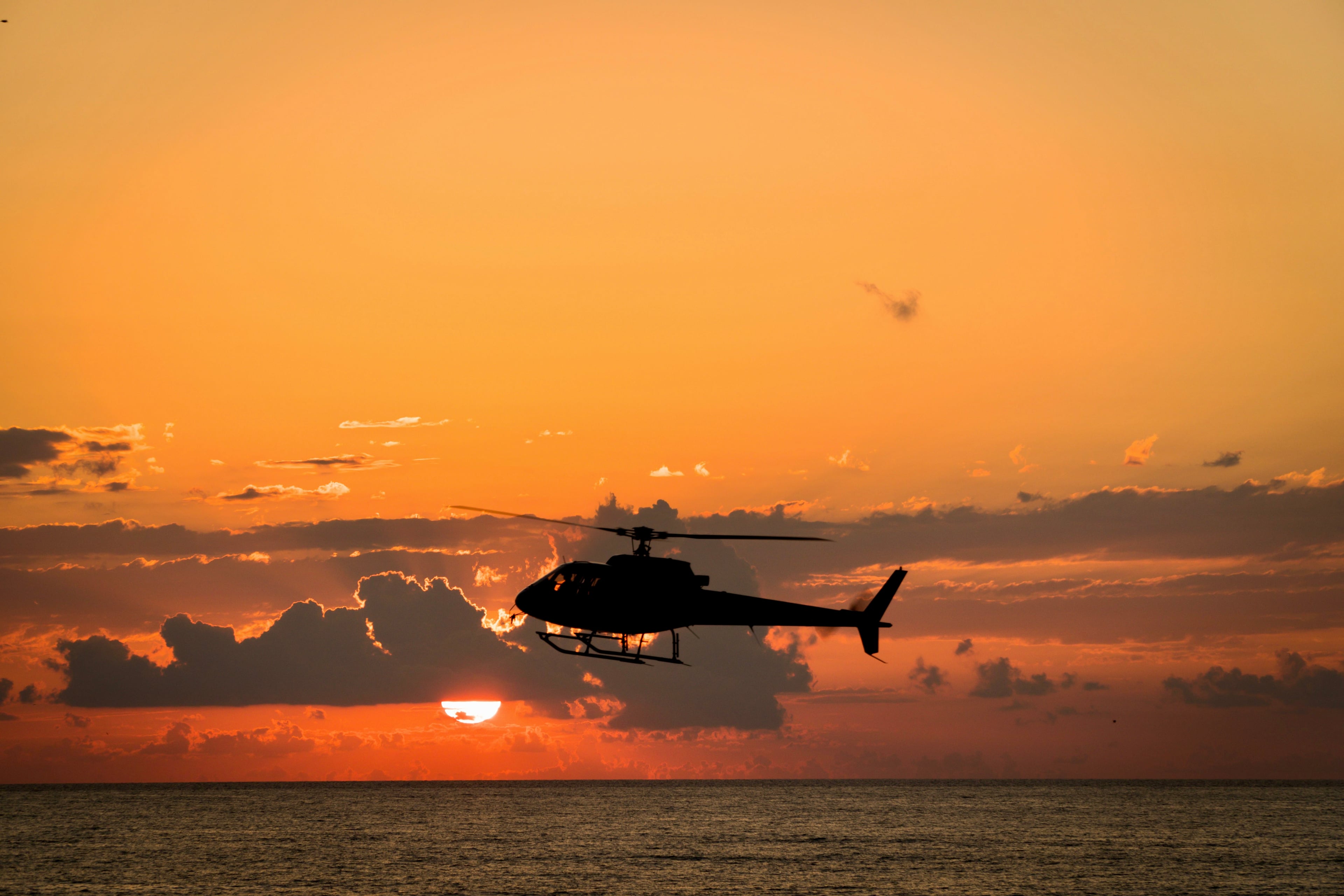 Elicottero in volo sul mare nella luce del tramonto